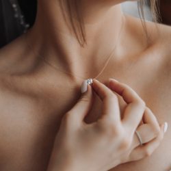 A,Woman,Is,Wearing,A,Necklace,And,Holding,It,Up A,Woman,Is,Wearing,A,Necklace,And,Holding,It,Up